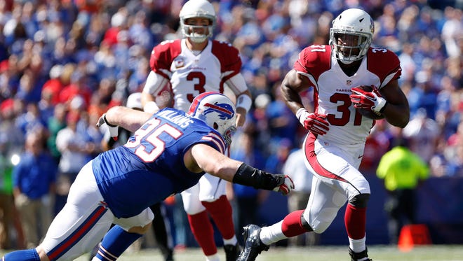 Arizona Cardinals running back David Johnson (31) runs with the ball and eludes a tackle by Buffalo Bills defensive tackle Kyle Williams (95) during the first quarter at New Era Field.