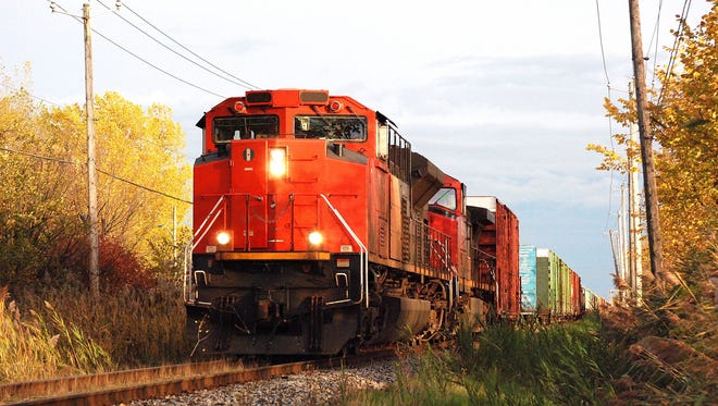 A long, slow, freight train, approaches the camera.