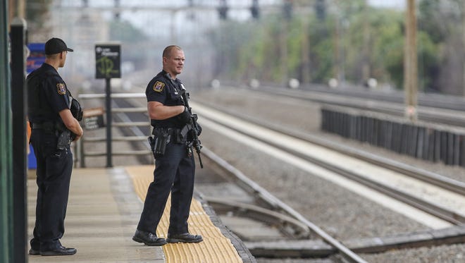 Police officers patrol the train station platform in Linden, N.J., several hours after bombing suspect Ahmad Khan Rahami was apprehended, on Sept. 19, 2016.