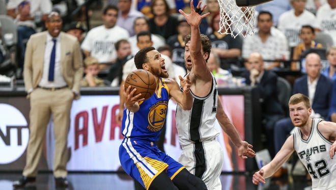 Golden State Warriors guard Stephen Curry shoots the ball as San Antonio Spurs center Pau Gasol defends during the second quarter in game three of the Western conference finals of the NBA Playoffs.