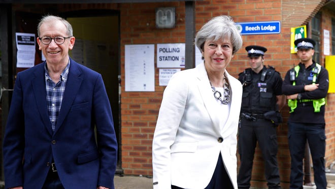 Britain's Prime Minister Theresa May leaves with her husband Philip after voting in the general election at polling station in Maidenhead, England, on June 8, 2017.