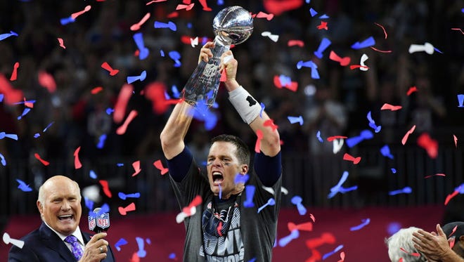 New England Patriots quarterback Tom Brady raises the Lombardi Trophy for the fifth time in his career, an NFL record for a quarterback.