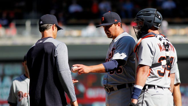 Tigers pitcher Blaine Hardy hands the ball with Brad Ausmus in the sixth inning of the Tigers' 5-4 win over the Twins Saturday in Minneapolis.
