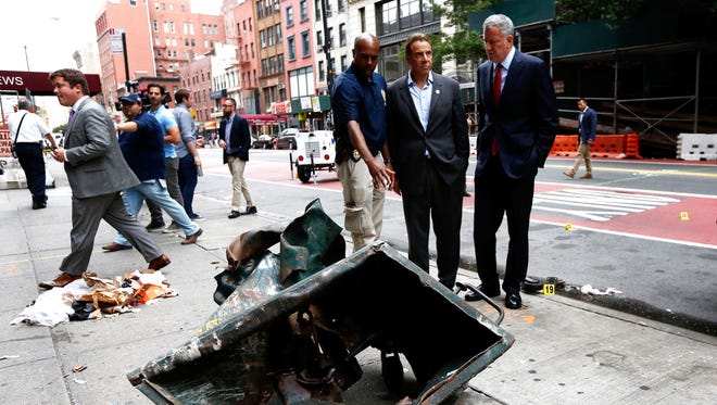 New York Mayor Bill de Blasio, right, and New York Gov. Andrew Cuomo, second from right, look over a mangled construction toolbox, Sept. 18, 2016, while touring the site of an explosion that occurred Saturday night in the Chelsea neighborhood of New York. Numerous people were injured in the blast, and the motive, while reportedly not international terrorism, is still being investigated.