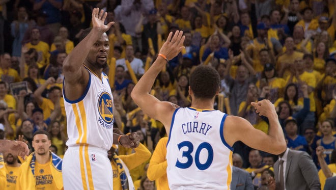 Golden State Warriors forward Kevin Durant celebrates with guard Stephen Curry during the second quarter in Game 1 of the Western Conference finals.