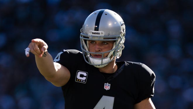 Oakland Raiders quarterback Derek Carr (4) gestures before the snap against the Indianapolis Colts during the first quarter at the Oakland Coliseum.