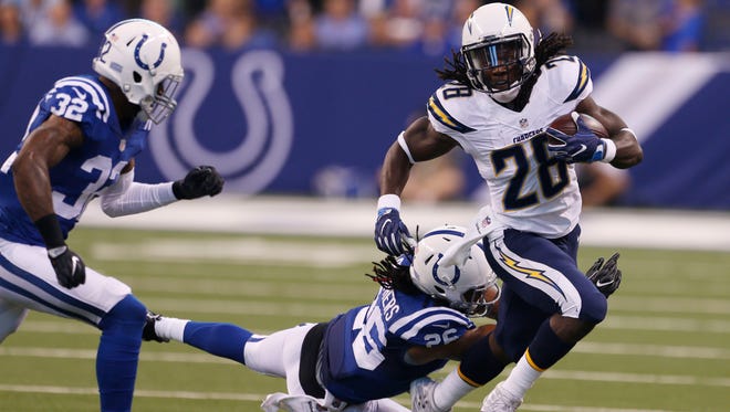 Chargers running back Melvin Gordon (28) runs with the ball as Colts safety Clayton Geathers (26) goes for the tackle.
