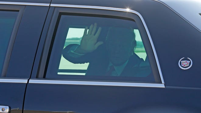 President Donald Trump waves to supporters from his limo before departing the 128th Air Refueling Wing at 1919 E Grange Avenue near General Mitchell International Airport in Milwaukee.