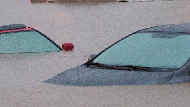 Cars are stuck in flood waters on Interstate 10 east at 43rd Avenue after monsoon rains flooded the freeway in Phoenix on Sept. 8, 2014.