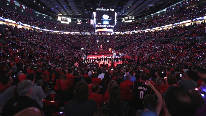 Fans take part in providing color from their lighted bracelets during the opening ceremonies before the game between the Portland Trail Blazers and the Utah Jazz.