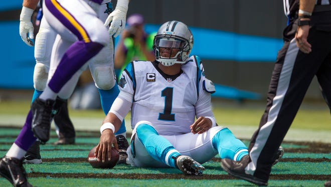 Panthers quarterback Cam Newton picks himself up off the turf after being sacked for a safety during the first half against the Vikings.