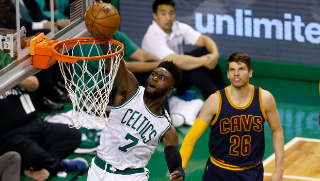 Boston Celtics guard Jaylen Brown dunks the ball while defended by Cleveland Cavaliers guard Kyle Korver during the first quarter in game one of the Eastern conference finals of the NBA Playoffs at TD Garden.