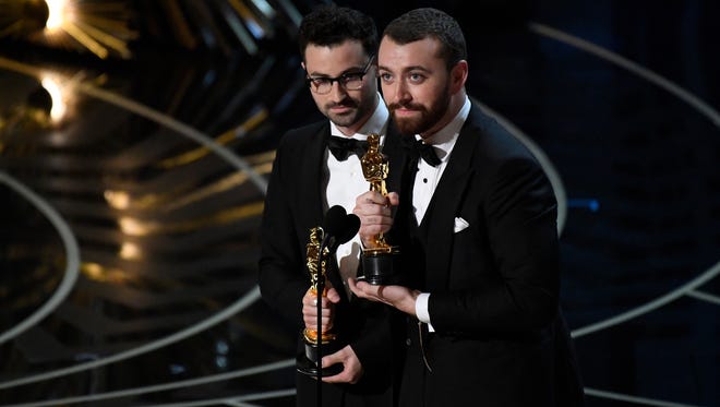 2016: Accepting best original song with co-writer Jimmy Napes, left, for " Spectre " theme " Writing ' s on the Wall, " British singer Sam Smith dedicated the award to the LGBT community, incorrectly saying that no openly gay man had won an Oscar before. Smith later publicly apologized to openly gay winner Dustin Lance Black, who wrote 2008 biopic " Milk.