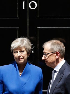 British Prime Minister Theresa May and her husband Philip stand on the doorstep of 10 Downing Street, London, after addressing the press Friday, June 9, 2017 following an audience with Britain's Queen Elizabeth II at Buckingham Palace where she asked to form a government.