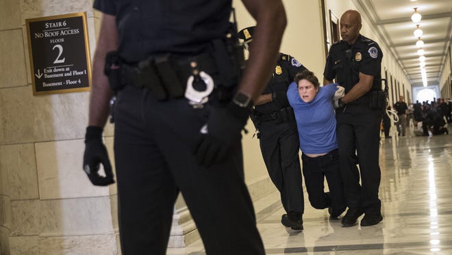 A protestor is arrested outside the office of Sen. Pat Toomey, R-Pa.,  while lobbying against the Senate GOP health care bill on June 28, 2017 in Washington.