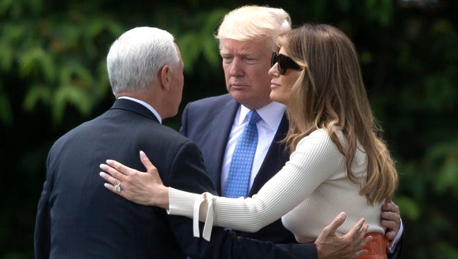 President Trump (C) and First Lady Melania Trump (R) are bid farewell by Vice President Pence (L) before the President and the First Lady depart the South Lawn of the White House by Marine One, in Washington, DC on May 19, 2017.