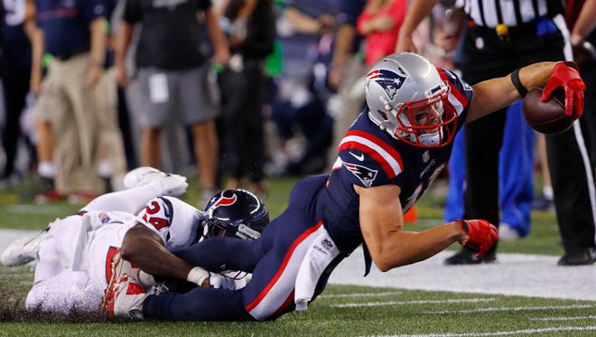 New England Patriots wide receiver Julian Edelman (11) stretches for a first down while being tackled by Houston Texans cornerback Johnathan Joseph (24) during the first half at Gillette Stadium.