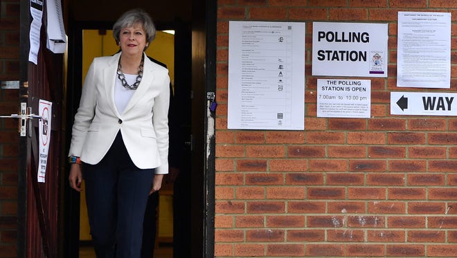 Britain's Prime Minister Theresa May leaves a polling station after casting her ballot west of London, on June 8, 2017, as Britain holds a general election.