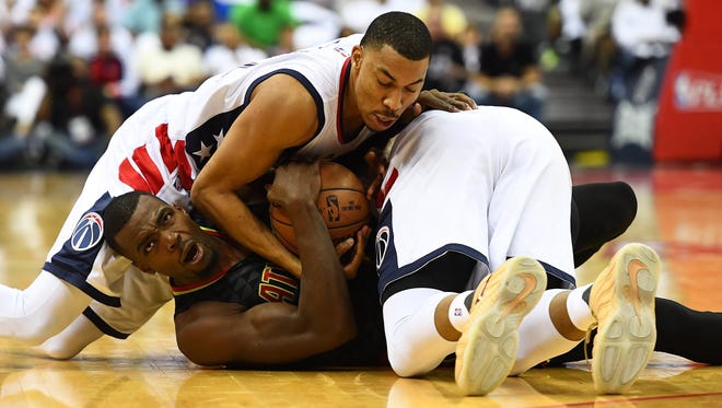 Atlanta Hawks forward Paul Millsap (4) and Washington Wizards forward Markieff Morris (right) and forward Otto Porter Jr. (left) fight for a loose ball during the second quarter in game one of the first round of the 2017 NBA Playoffs at Verizon Center.