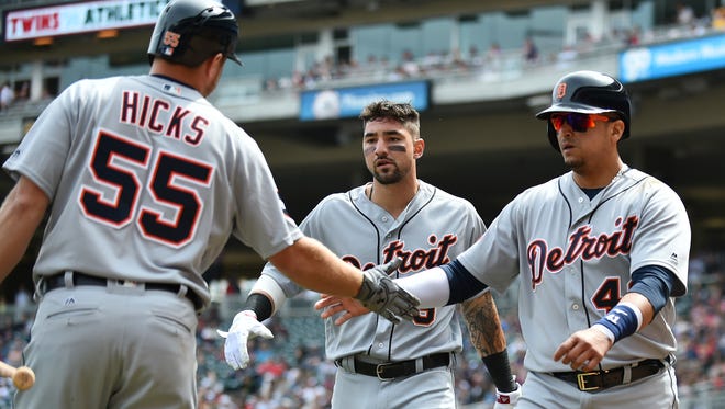 Tigers designated hitter Victor Martinez, right, gets a handshake from teammate John Hicks after he and Nick Castellanos, center, scored in the third inning Sunday, April 23, 2017, at Target Field in Minneapolis.