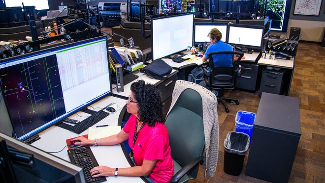 Cathy Jay, communications specialist, left, and Rebecca Rudd, distribution operations supervisor, work in the APS Distribution Operations Center in Phoenix, Monday, June 19, 2017.  The function of the Center is to keep power flowing to all APS electric customers in Arizona, especially during the hot summer months.
