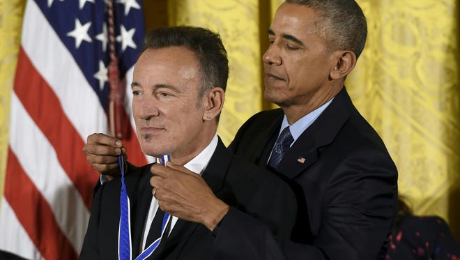 US President Barack Obama presents musician Bruce Springsteen with the Presidential Medal of Freedom.