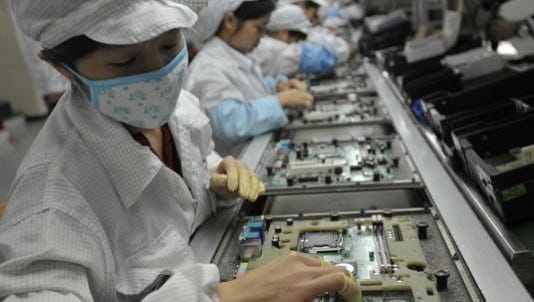 Workers assemble electronics products at a Foxconn Technology Group factory in Shenzhen, China in 2010.