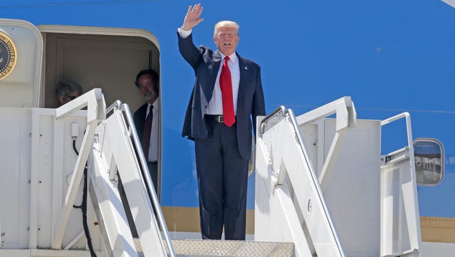 President Donald Trump waves as he returns Tuesday afternoon to the Milwaukee-area where he was expected to talk about health care, tout job apprenticeships and raise cash for Gov. Scott Walker.