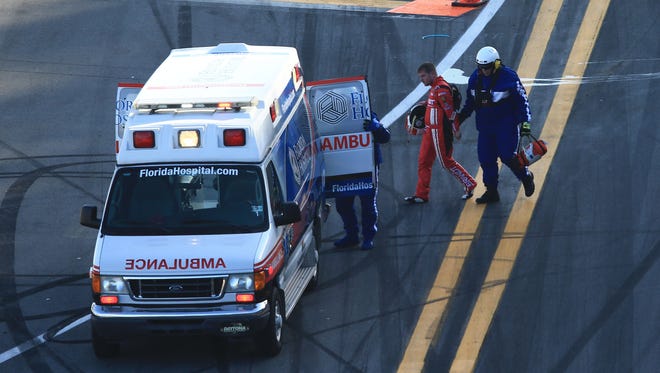 Justin Allgaier (in red) is helped to an ambulance by medical safety personnel during the 2015 Daytona 500.