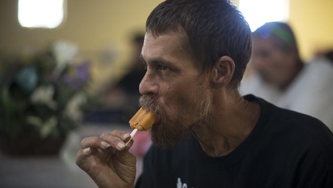 Steve Sargen eats a popsicle during summer heat relief hours on June 16, 2017, at the Society of St. Vincent de Paul's Phoenix dining room.
