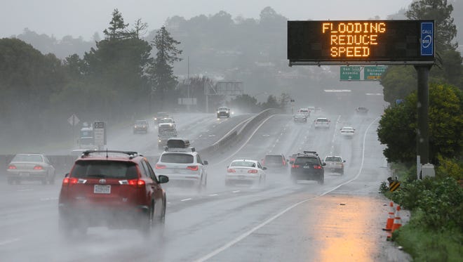 A sign warns motorists of flooding on northbound Highway 101 on Feb. 20, 2017, in Corte Madera, Calif. Heavy downpours are swelling creeks and rivers and bringing threats of flooding in California's already soggy northern and central regions. The National Weather Service map shows floods, snow and wind advisories for the northern part of the state.