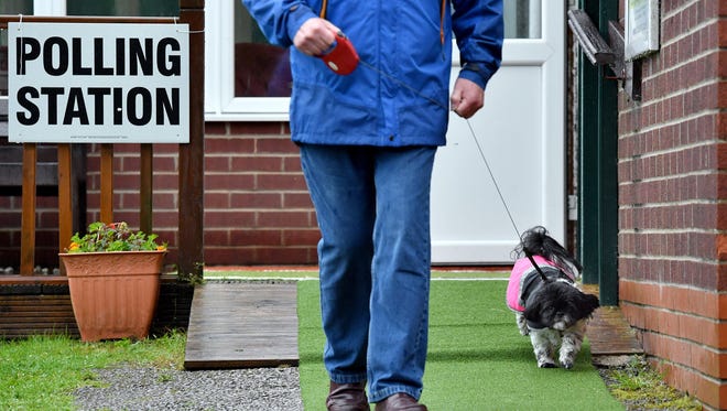 A voter leaves a polling station with his dog in Stalybridge.