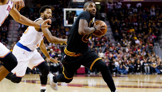 Kyrie Irving drives to the basket past Derrick Rose.