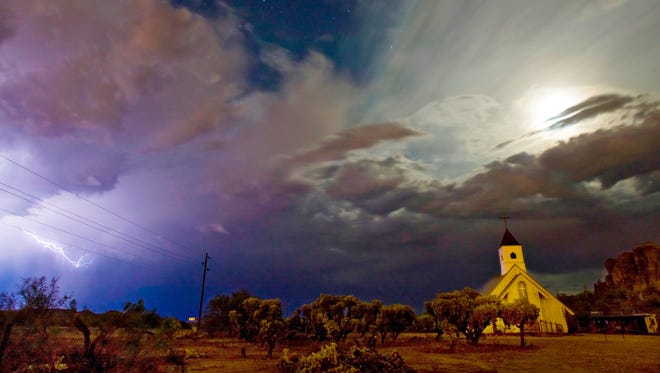 The moon illuminate the clouds above the Elvis Presley Chapel at the Superstition Mountain Museum in Apache Junction as lightning from a monsoon storm dances across the sky to the west on Sept. 8, 2009.