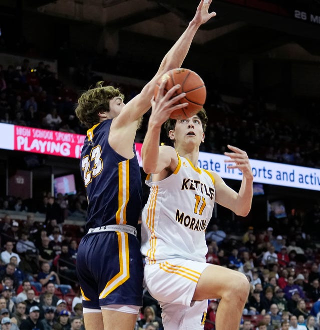 Marquette's Nolan Minessale (23) attempts to block Kettle Moraine's Nathan Vuillaume (11) during the first half of the WIAA Division 1 boys basketball state semifinal game on Friday March 15, 2024 at the Kohl Center in Madison, Wis.