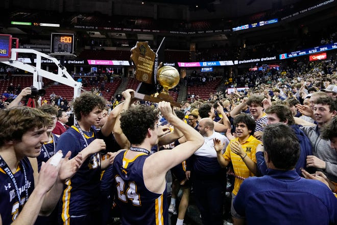 Marquette players hold up the WIAA Division 1 boys basketball state championship trophy after defeating Arrowhead on Saturday March 16, 2024 at the Kohl Center in Madison, Wis.