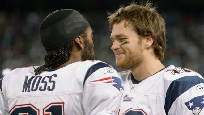 Brady chats with wide receiver Randy Moss after setting the single-season records for passing touchdowns (50) and receiving touchdowns (23) in the Patriots' 16-0 2007 season.
