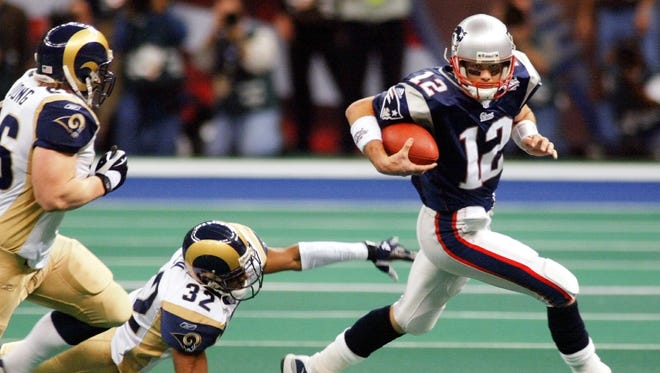 Brady evades pressure during the Patriots' 20-17 win in Super Bowl XXXVI over the St. Louis Rams in New Orleans, Brady's first title.