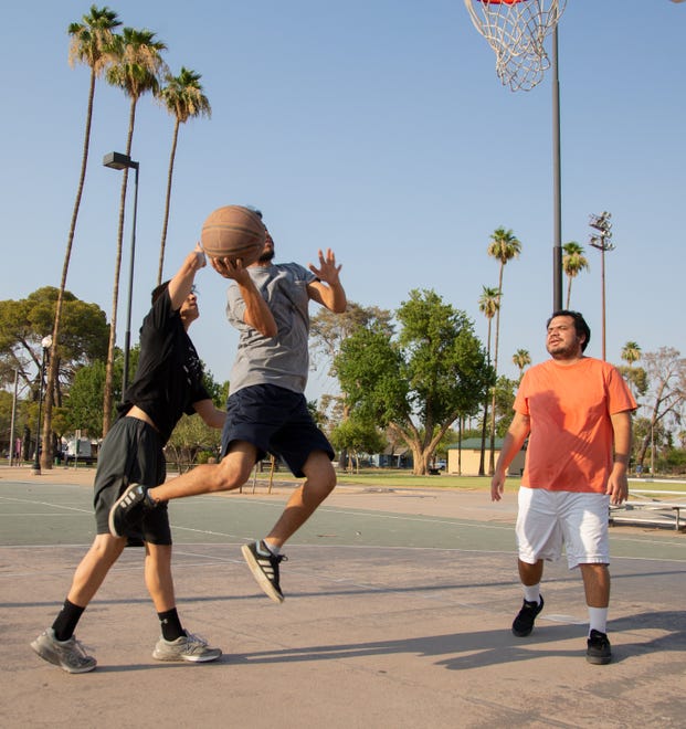 Hugo Martinez attempts a layup by Isaiah Ford and Julio Martinez at Coronado Park in Phoenix on June 17, 2021. Thursday's temperature of 118 degrees broke a daily record set in 2015.