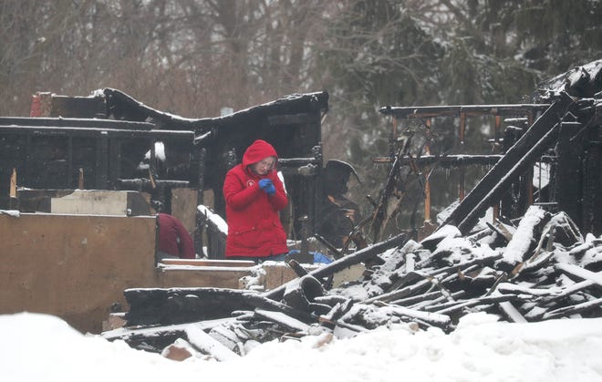 A woman, who said she was with law enforcement, looks through the rubble of a home destroyed by fire at S15 W22398 Arcadian Ave. in the Town of Waukesha on Wednesday, Feb. 20, 2019. The early morning fire killed three people, and injured three others on Tuesday, Feb. 19.